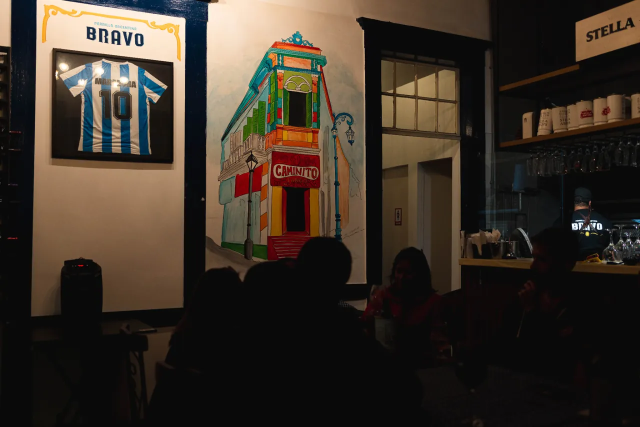 Interior do Bravo Parrilla com referências argentinas, bar e clientes