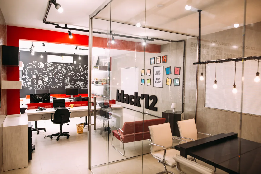 Escritório da Black12 com recepção, área de trabalho e sala de reunião
